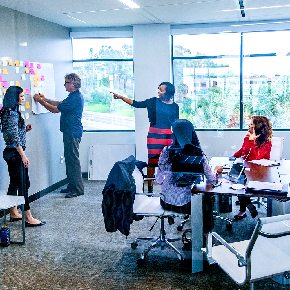 Group of Xcel employees having a discussion in a office meeting room